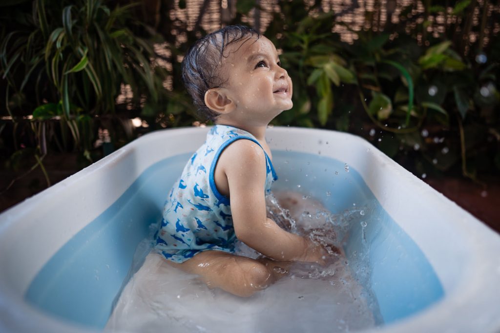 baby splashing water in bath tub